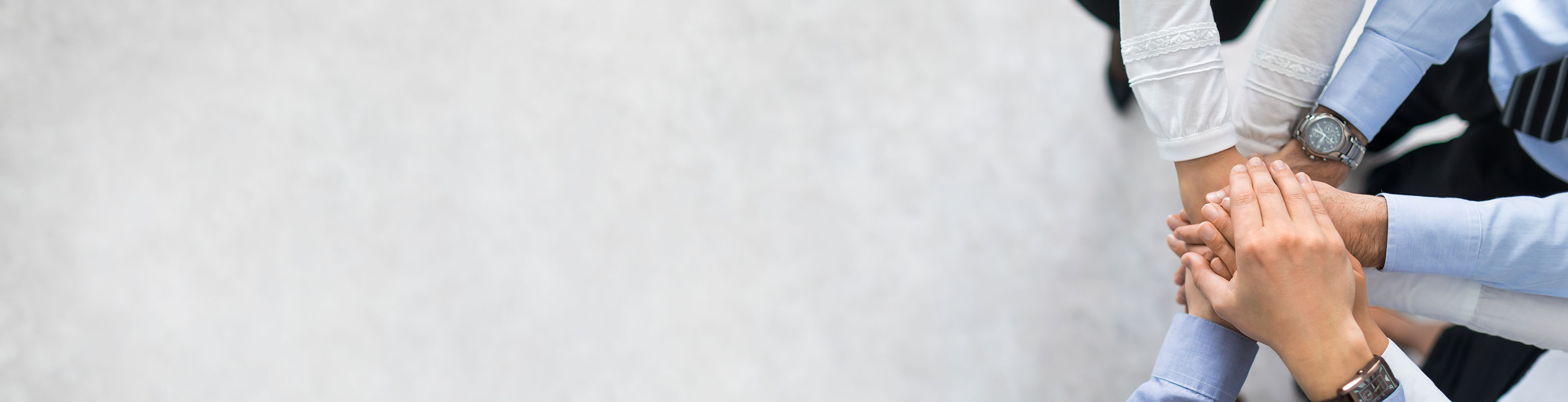 Vier Personen machen einen Stapel aus ihren Händen